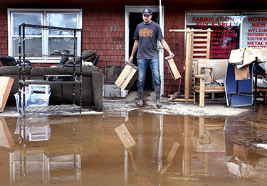 Dave Philips clears flood damage at his shop, DC Kustoms