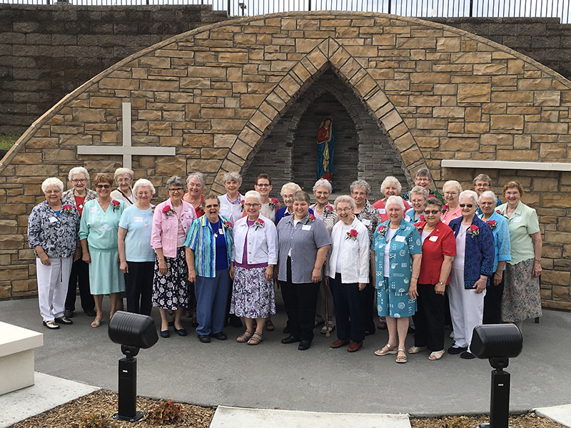 A group of Franciscan Sisters of Perpetual Adoration smile in front of the Garden View Grotto